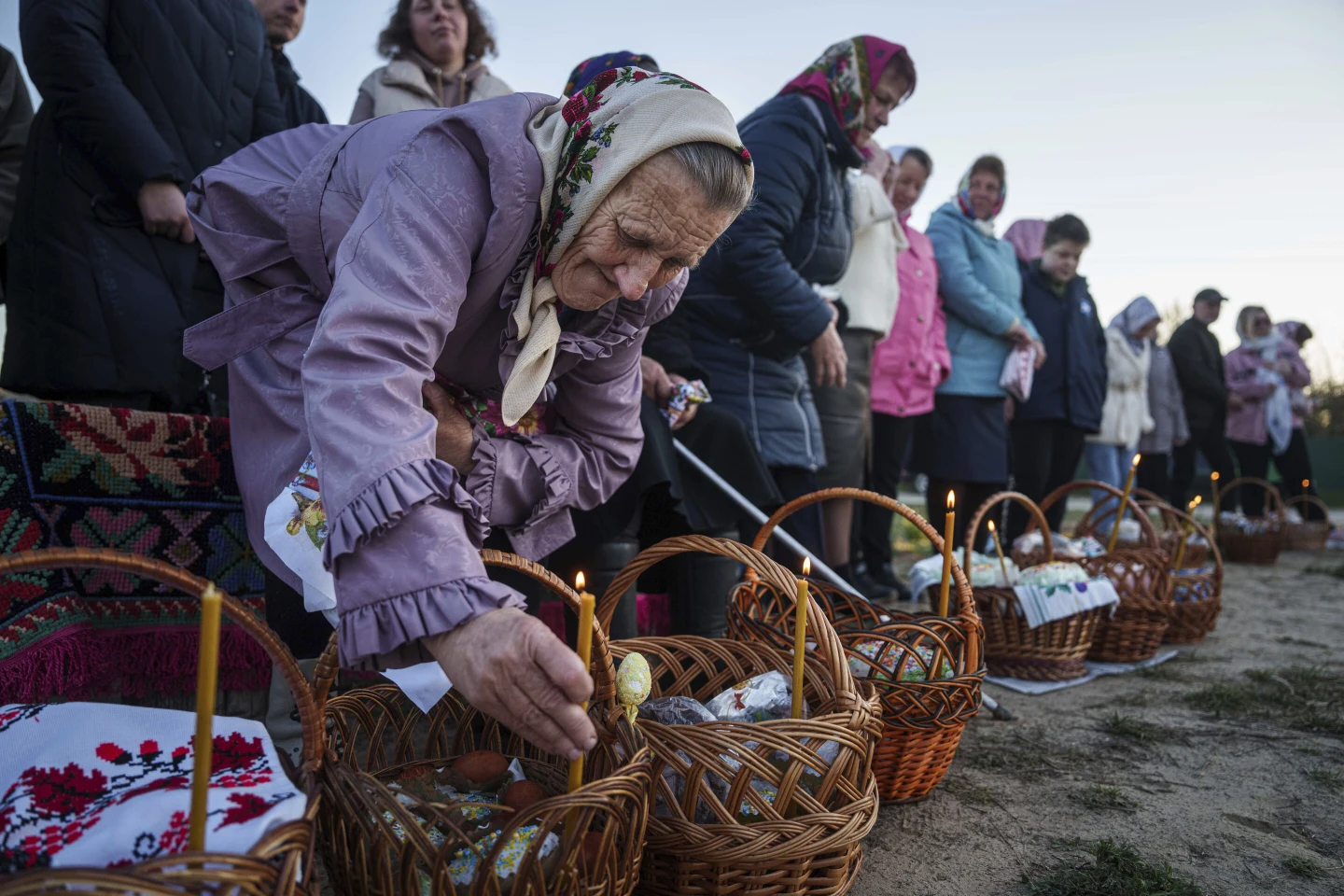 Літня жінка готує свої великодні кошики для освячення під час святкування православного Великодня в селі Красне, Україна, у неділю, 20 квітня 2025 року.